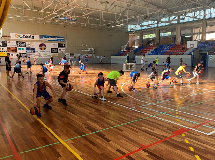 Infants entrenant bàsquet a la pista del CB Sant Feliu